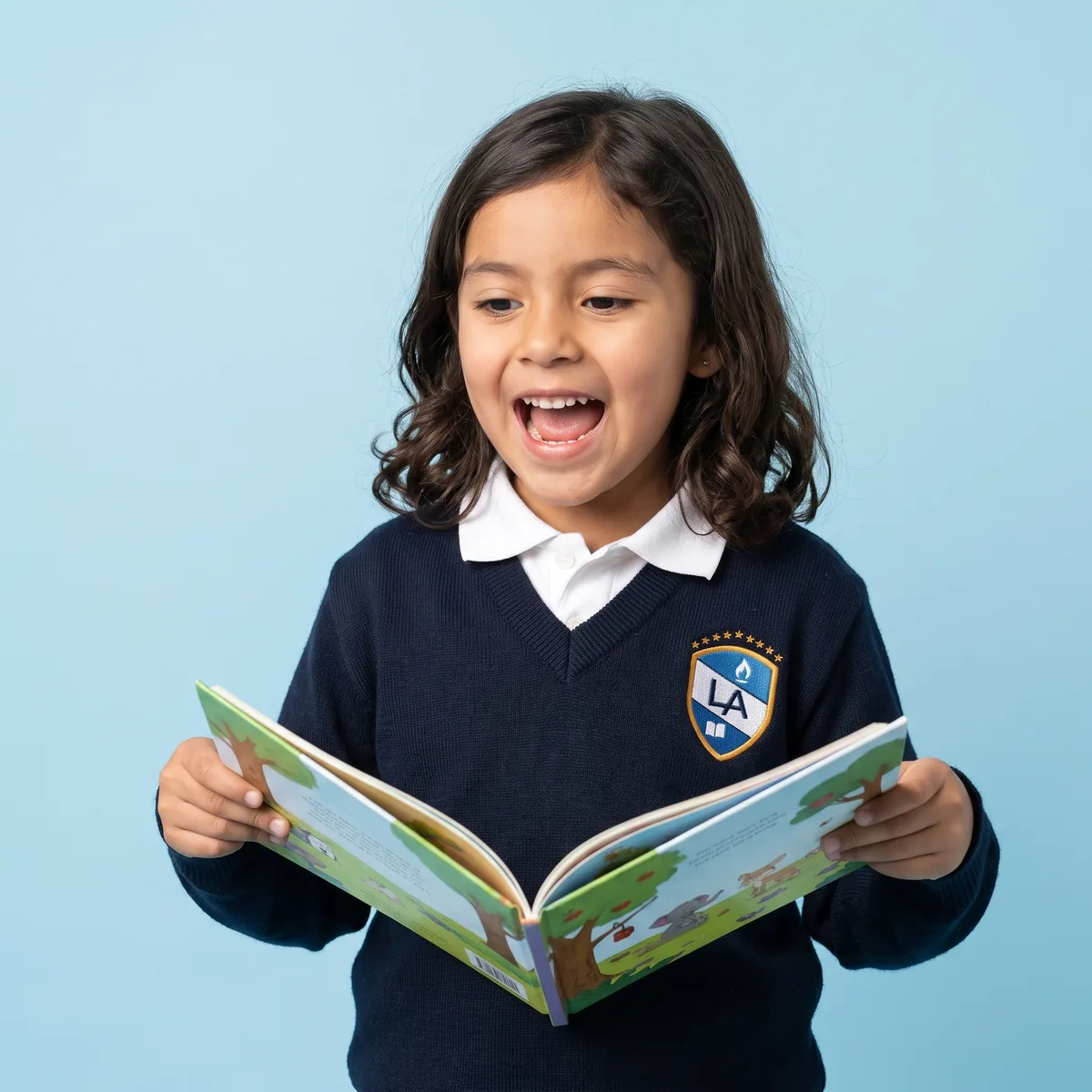Niña de primaria lee en voz alta un libro ilustrado