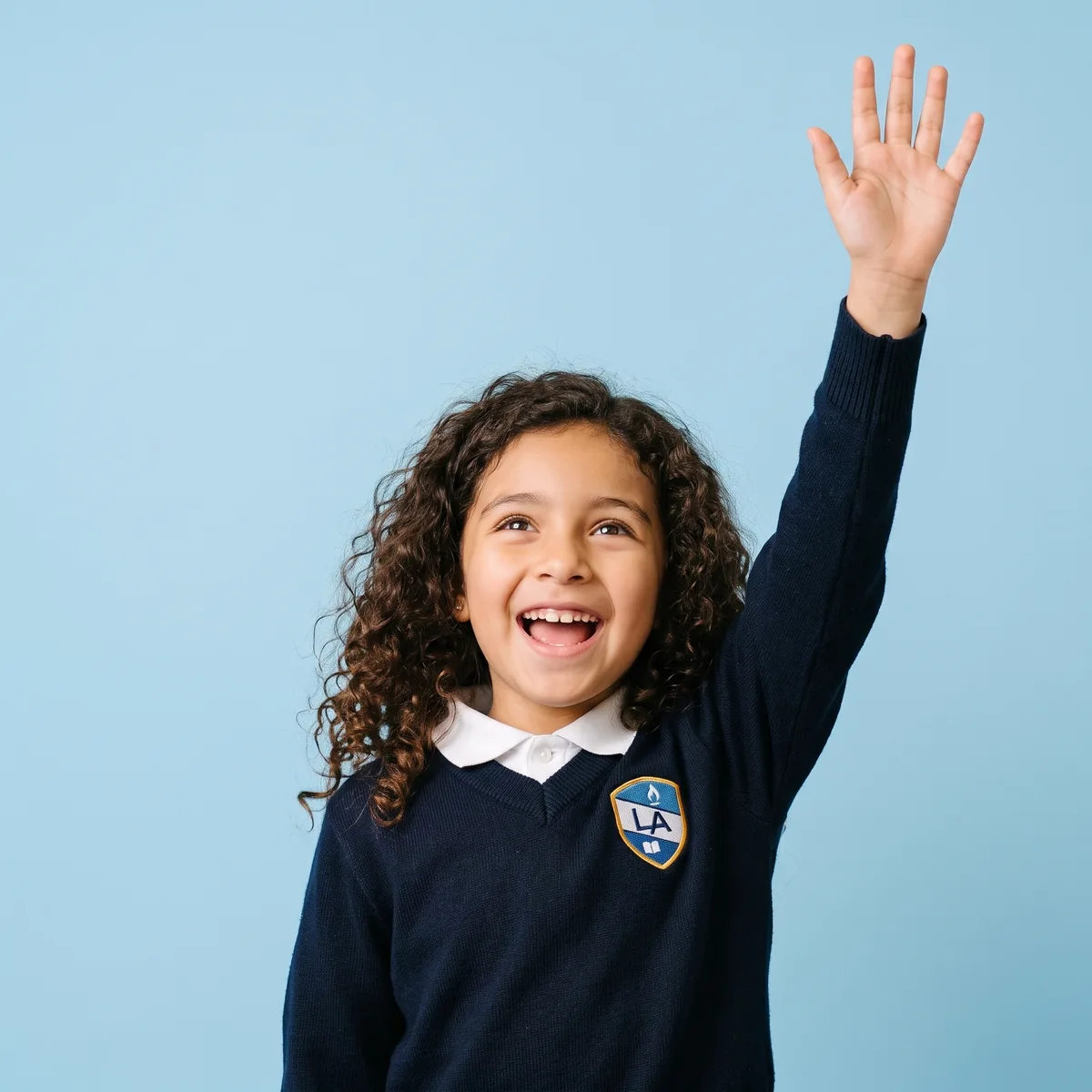 Niña de primaria levanta la mano para participar en clase
